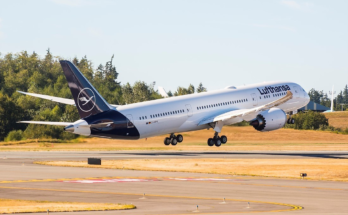 a commercial airliner with wheels down above a runway